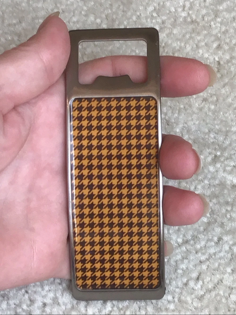 Curved Houndstooth Bottle opener, Silver/Black/Orange, 4 1/2” x 1 1/2”